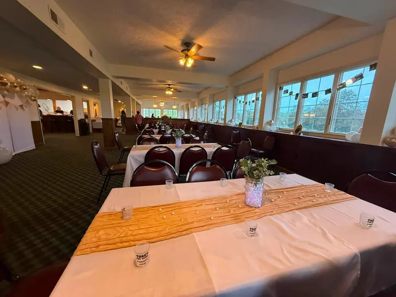 Banquet tables arranged throughout the bright window-lined sunroom